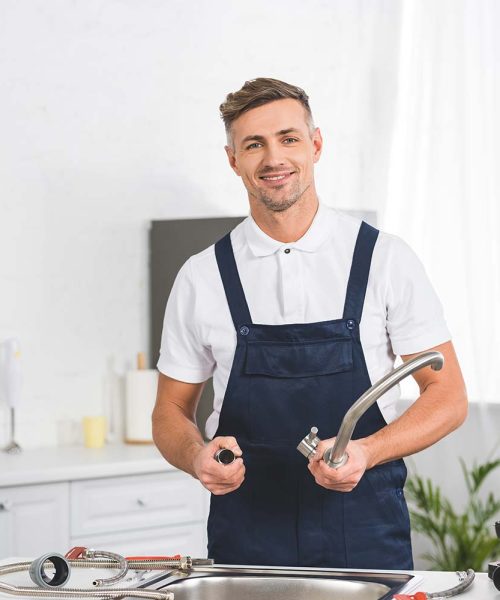 smiling-adult-repairman-taking-off-kitchen-faucet-resize.jpg